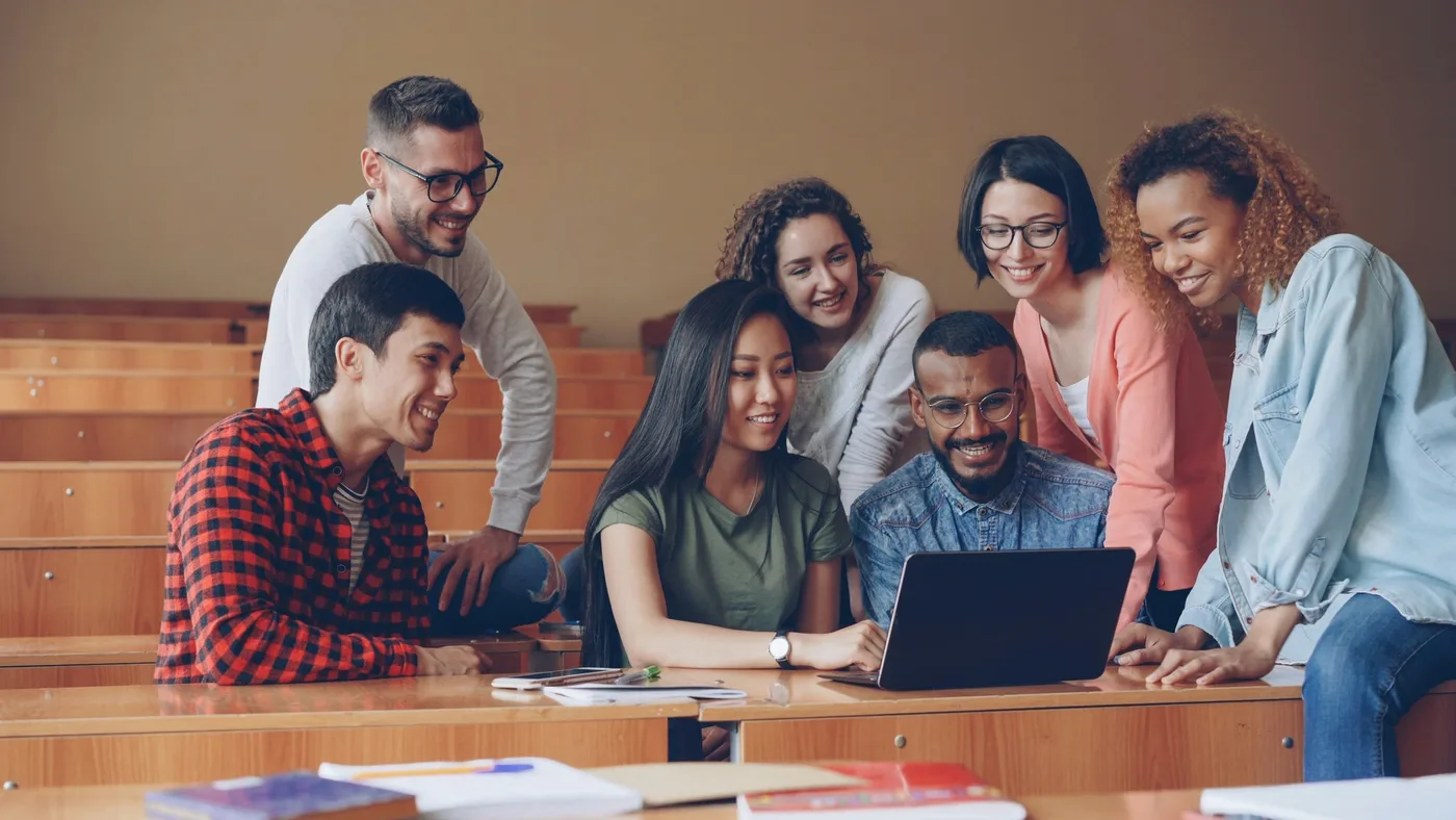 College students reviewing work together in a classroom.